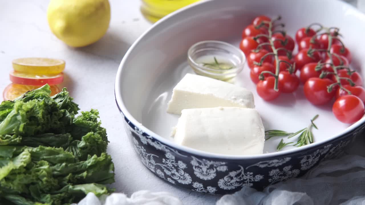 페타 치즈, 토마토, 허브 를 넣은 그리스식 요리 를 준비 하고 있다