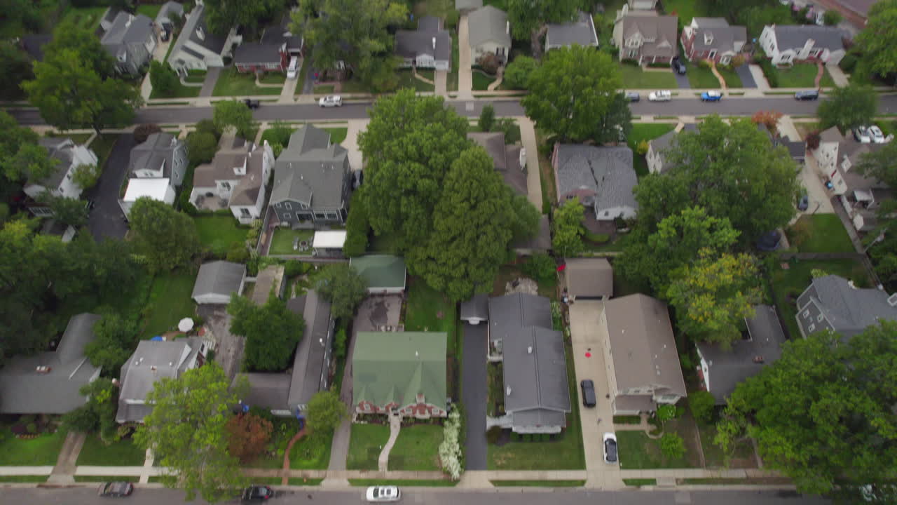 Flyover and tilt down over houses in suburban neighborhood in St