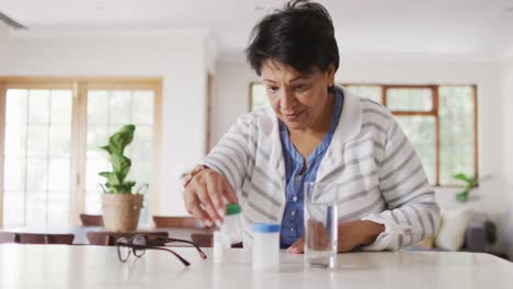 Asiatische-Seniorin-überprüft-Ihre-Medikamentenbehälter-Im-Wohnzimmer-Zu-Hause