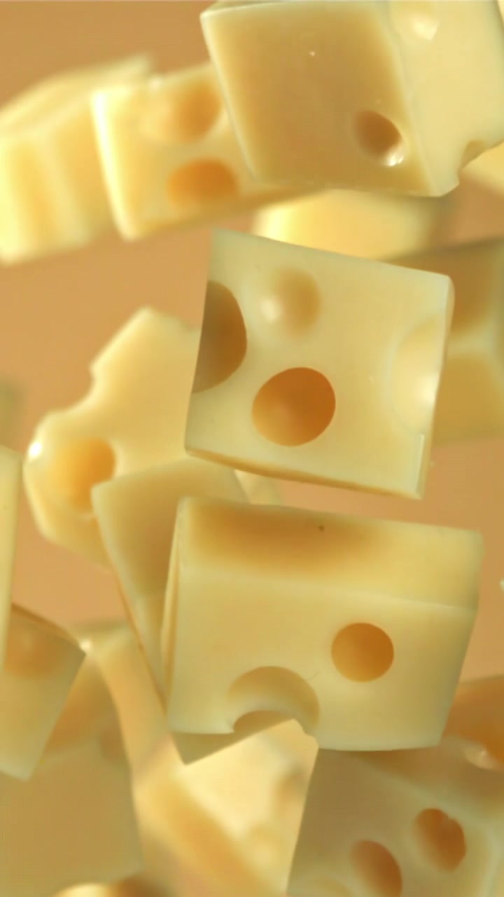 Deliziosi cubetti di formaggio svizzero che cadono al rallentatore.