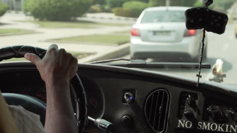 SLOW-MOTION:-Left-hand-traffic-driver-in-old-car-holding-steering-wheel