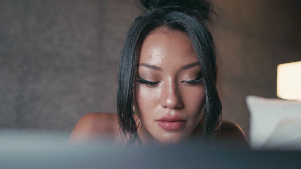 Woman using laptop in bed