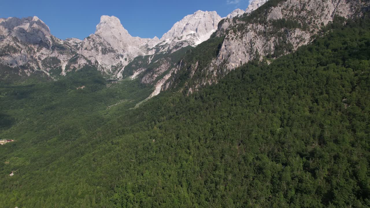 montañas épicas de los alpes en albania con picos rocosos y laderas verdes cubiertas de bosque