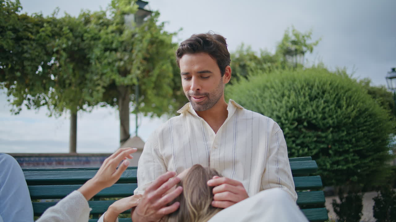 평화로운 연인들이 포옹하는 공원 휴가 클로즈업. 벤치에서 안고 있는 커플