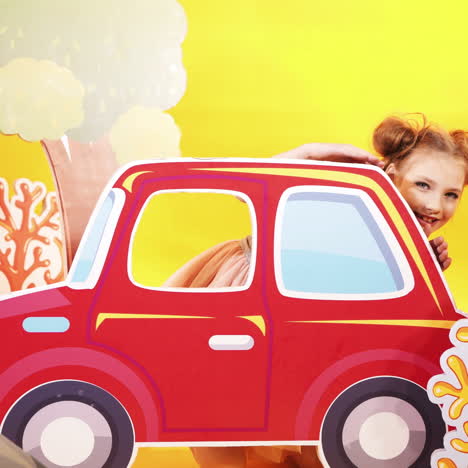 funny little girl on a bright yellow wall background. a beautiful child plays with a large toy car. square video