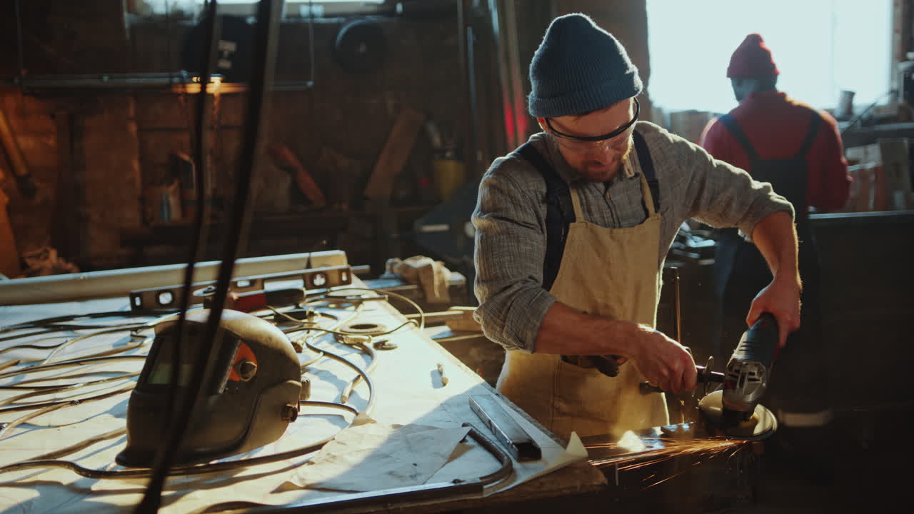 herrero usando una molienda angular para dar forma a detalles metálicos en el taller