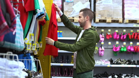 hombre comprando ropa para niños en una tienda minorista
