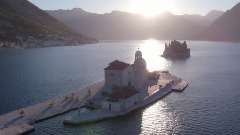 magical bright sunlight shines on church of our lady of the rocks, montenegro