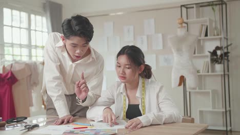 two young asian fashion designers sketching at fashion design studio