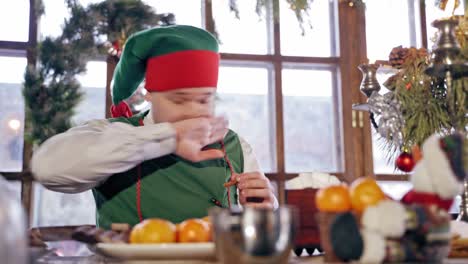 elf eating at table. santas elf eating christmas dinner at table