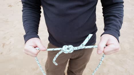 man showing how to make corrext reef knot and then granny knot.