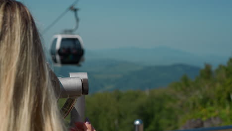 Female-tourist-adjusts-tower-viewer-at-cable-way-station