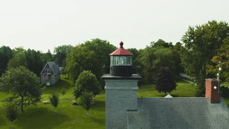 drone shot of the big light house museum push in on the large lens at sodus point new york vacation spot at the tip of land on the banks of lake ontario