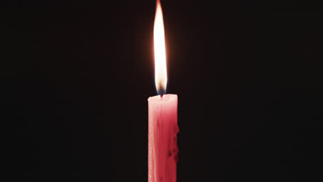 video of red candle with white flame and copy space on black background