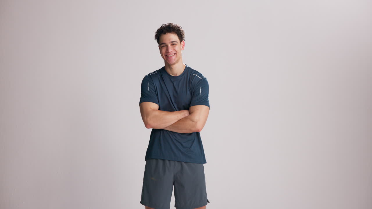Young Man in Athletic Wear Standing with Arms Crossed and Smiling