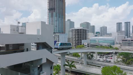 metromover rail car moving on elevated track above highway in modern city. public passenger transport concept. miami, usa