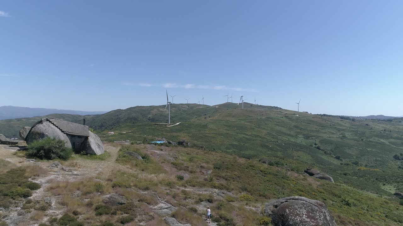 воздушный вид дома в горах с ветряными мельницами