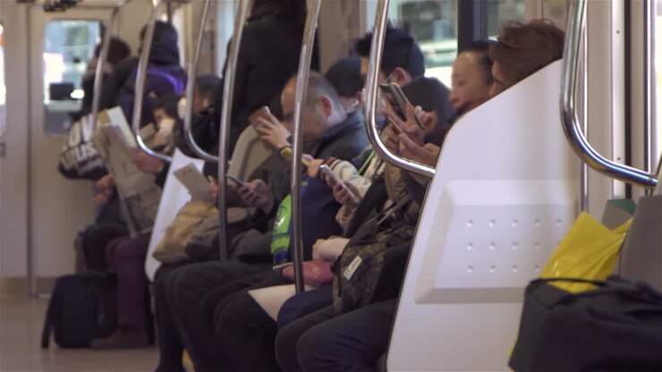 Pendolari che usano smartphone sul treno