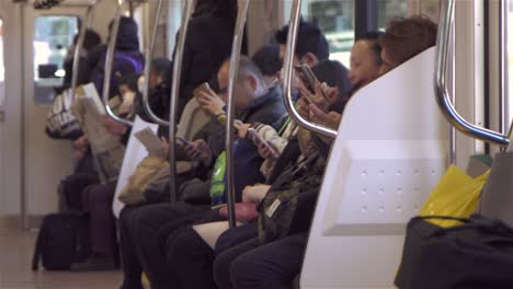 commuters using smartphones on train