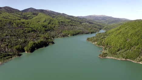 Stilles-Seewasser-Mit-üppigen-Grünen-Hügeln-An-Einem-Sonnigen-Tag