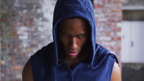 portrait of african american man wearing hoodie sweating after exercise looking at camera in urban b