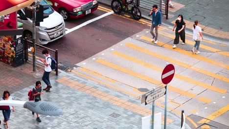 pedestrians navigate crosswalk in urban hong kong