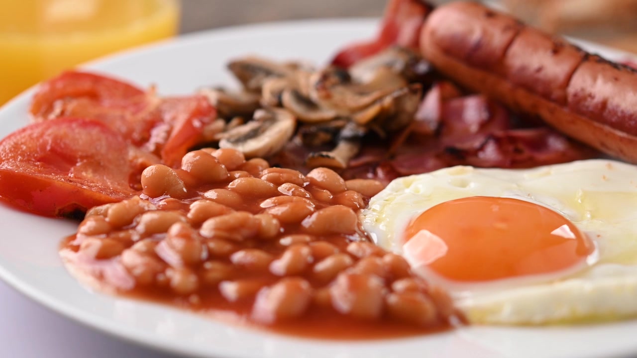 Colazione inglese completa con uovo fritto, pancetta, salsicce e fagioli