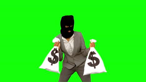 burglar wearing balaclava and holding money bags on green screen