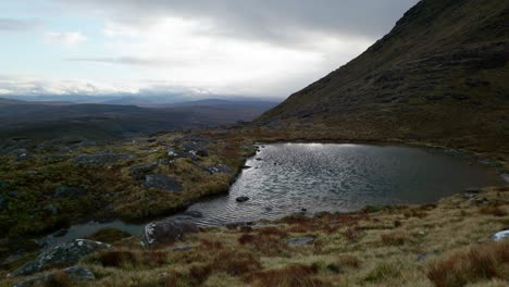 Unter-Einem-Dunklen,-Stimmungsvollen-Himmel-Weht-Der-Wind-über-Einen-Kleinen-Lochan-Im-Schottischen-Hochland