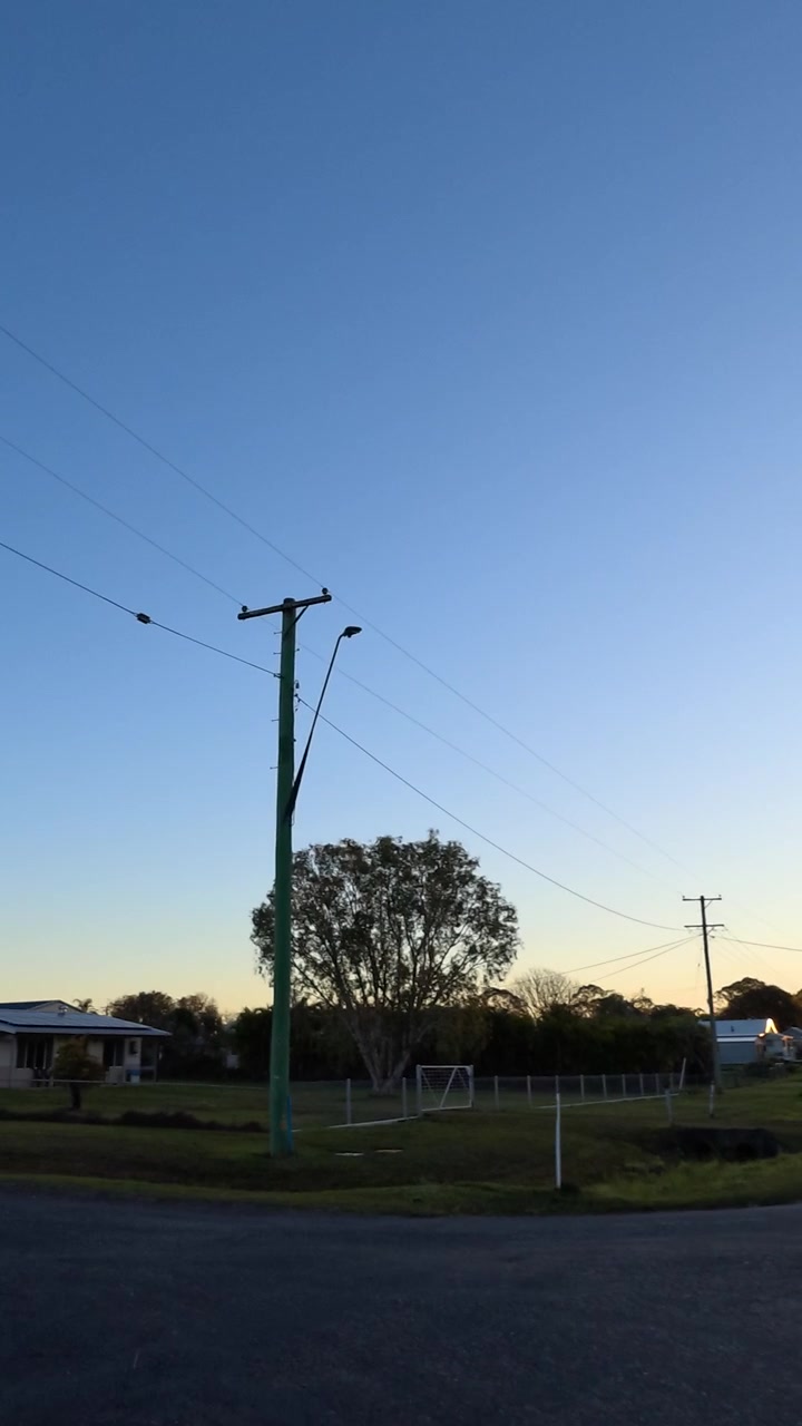 Wide angle view driving down a quiet country street during golden hour in Australia.
