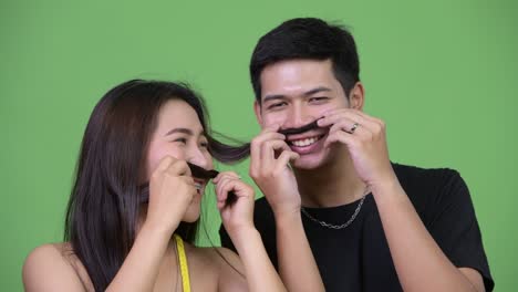 young asian couple playing with hair together