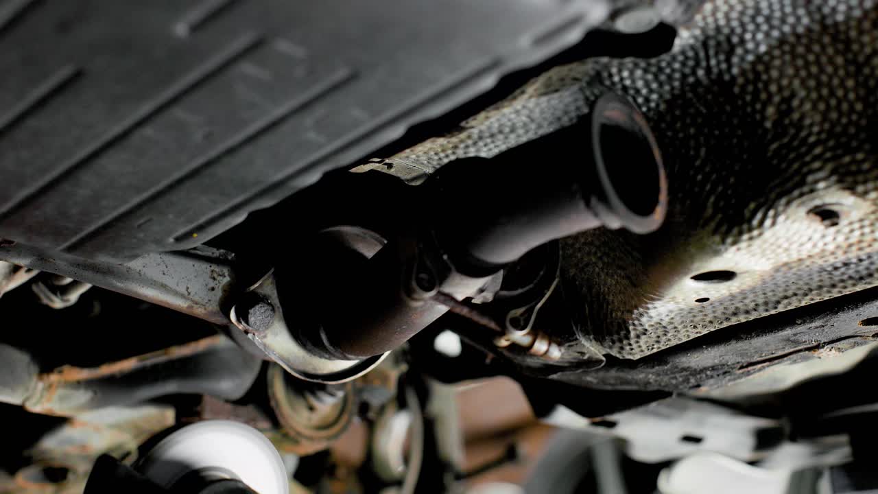 Cutting a seized rusty bolt under a car with an angle grinder. Lots of sparks. Static close up in 4k.