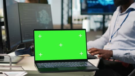 technician using mockup laptop next to office coworkers developing applications