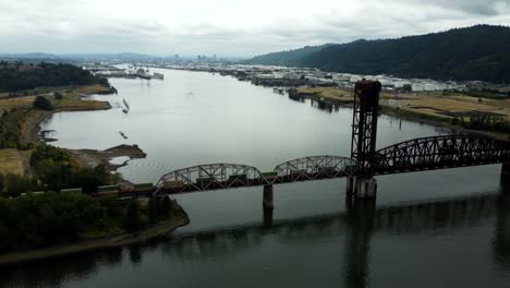 us, oregon, portland, st johns, 2025-07-26 - drone view of a freight train going across the train bridge
