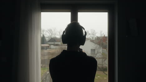 student listening music while looking out of a window