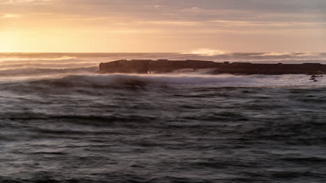 time-lapse of sun setting over ocean and illuminating a jetty