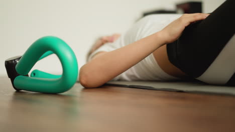 sportswoman performs exercises lying on mat closeup. fitness-oriented woman in sports clothing does sports in domestic exercise zone. workouts at home