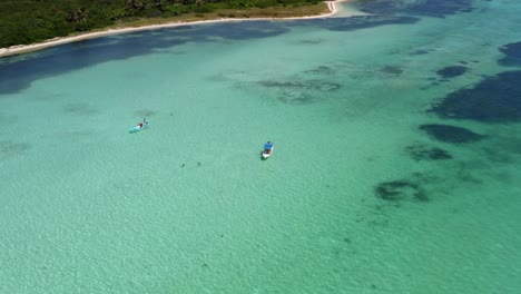 stunning aerial bird's eye top view of small tour boats in the middle of a sea of crystal clear turquoise water in the beautiful nature reserve of sian ka'an near tulum, mexico