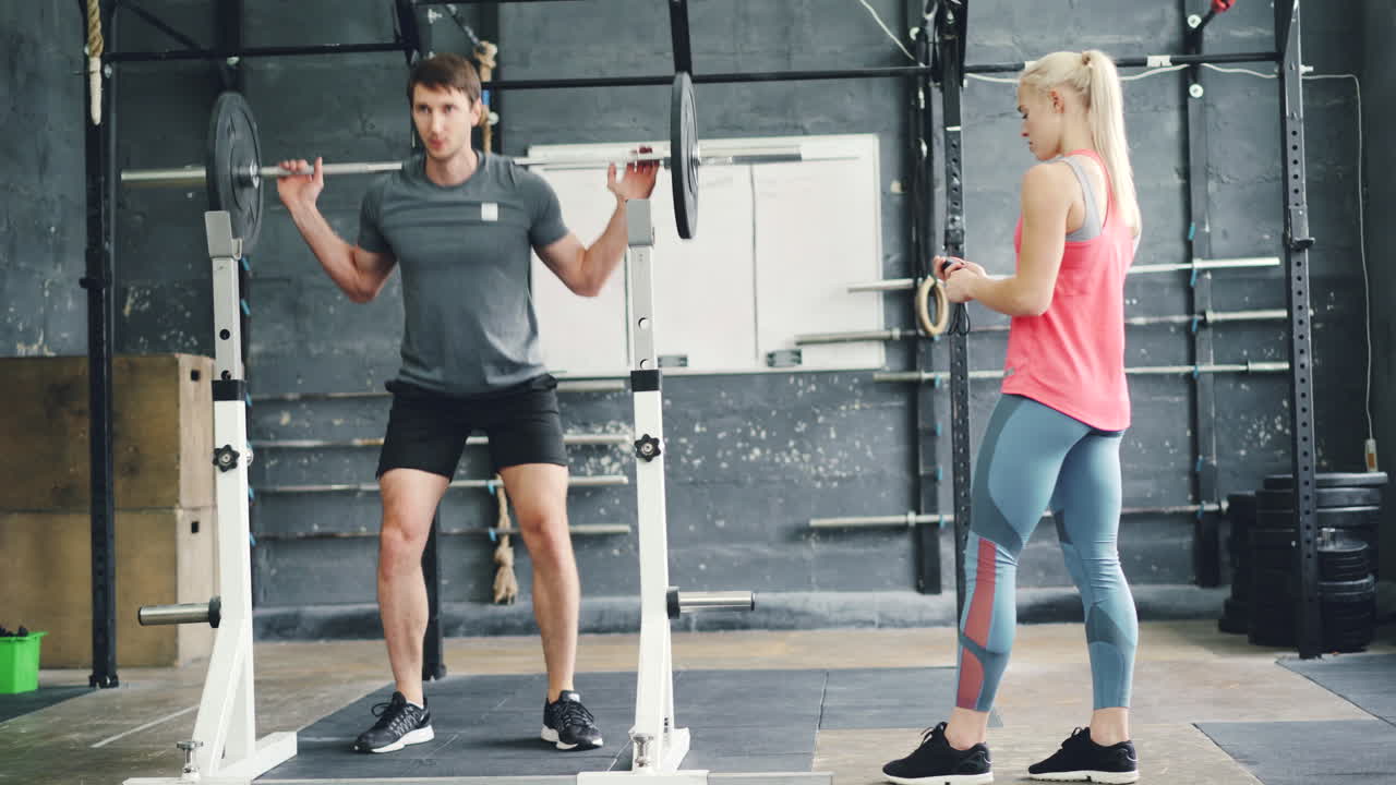 Uomo che solleva pesi con un personal trainer
