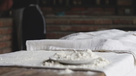 baking cloth and flour mess left on a wooden table in the kitchen