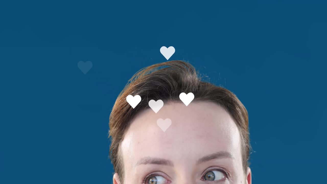 Animation of heart shapes flying over caucasian young woman raising eyebrows over blue background