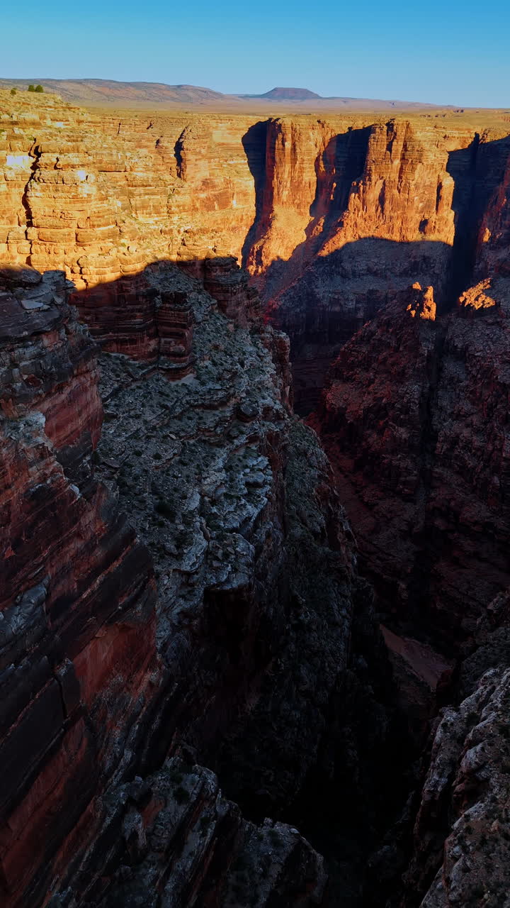 Drone footage among the layered geological formations in the deep canyon. Bright sun lights the tops of the rocks. Marble Canyon, Coconino County, Arizona, United States. Vertical video