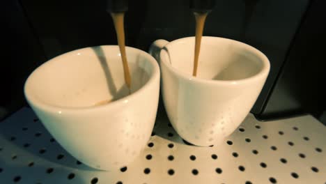 Home-coffee-machine-making-two-espresso-coffees,-slowly-coffee-drops