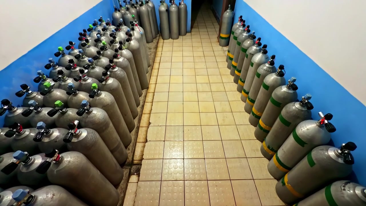 Filas de tanques metálicos organizados en un espacio interior alicatado, concepto de almacenamiento de equipos
