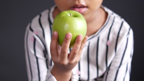 niño sosteniendo una manzana verde
