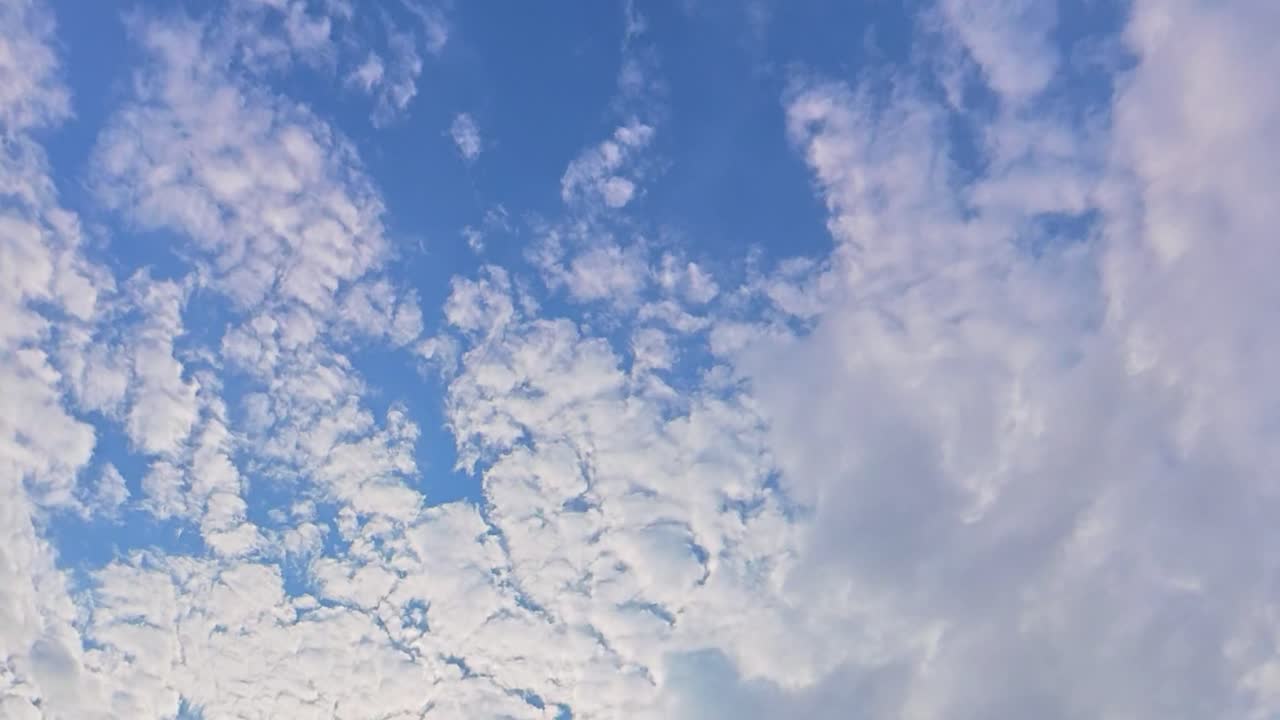 Dynamic timelapse of fluffy clouds moving across a bright blue sky