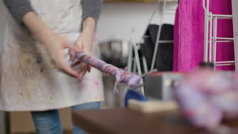 woman putting yarn onto a mechanical skein roller and rolling it up