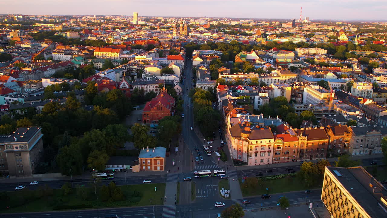 Luftfoto over den gylne byen Krakow om kvelden, med opplyste bygninger ved solnedgang og kjørende biler på veien, Polen