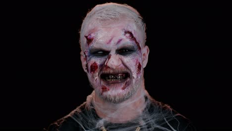 hombre diablo siniestro con halloween aterrador maquillaje de zombies muertos en disfraz haciendo caras, tratando de asustar