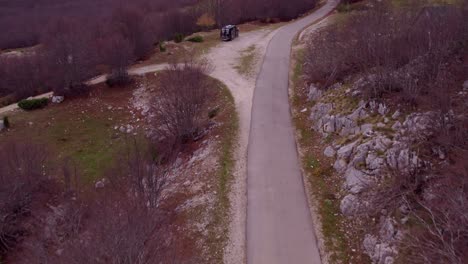 Reveal-shot-of-Durmitor-National-Park-Montenegro-with-camper-van-parked-next-to-road,-aerial